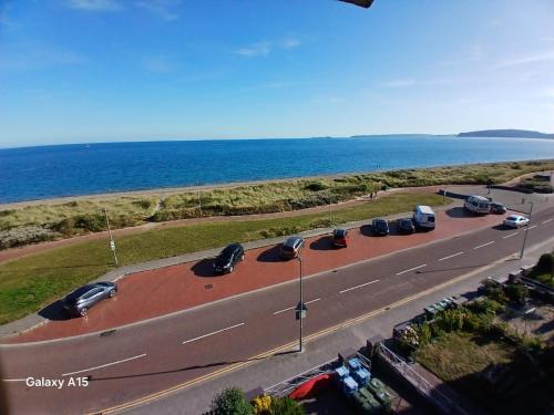 an overhead view of a road with cars parked next to the ocean at Sea View Double 1st Floor in Pwllheli