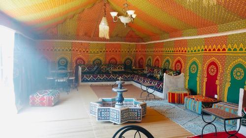 a living room with colorful walls and a table and chairs at Ez-zine Glam in El Aadamna
