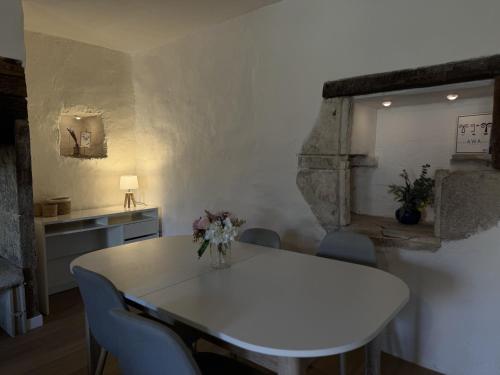 a dining room with a white table and chairs at Petite maison de vacances in Alvignac