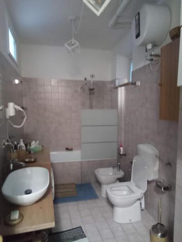 une salle de bain avec toilettes, baignoire et lavabo dans l'établissement Civico 17 di Luciani Luciana, à Venzone