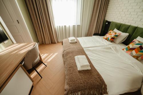 a bedroom with a bed with two towels on it at Villa Botar in Cluj-Napoca