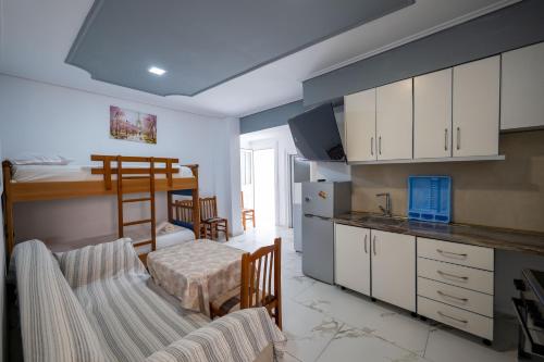 a room with a kitchen and a bunk bed at Andy Apartments in Sarandë