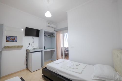 a small bedroom with a bed and a window at Andy Apartments in Sarandë
