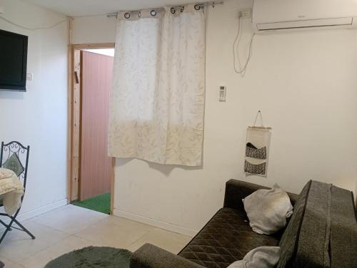 a living room with a couch and a window at מקסימה עם חצר במרכז העיר in Eilat