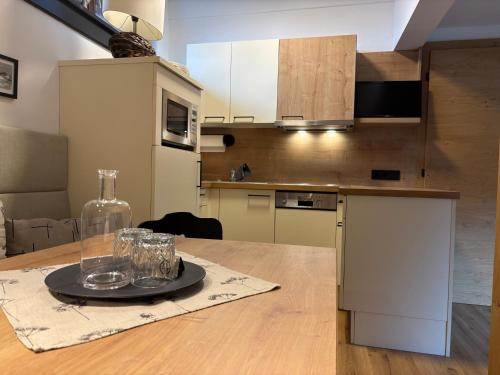 a kitchen with a table with a bottle and glasses on it at Ferienwohnungen Monika Winter in Kleinarl