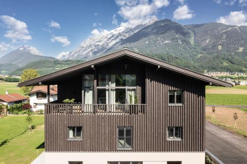 a house with a balcony with mountains in the background at Schlosshotel Mitterhart in Schwaz