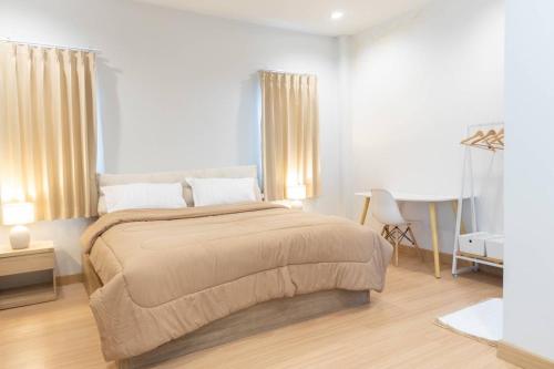 a bedroom with a large bed and a desk at Pani House in Ban Nong Chaeng