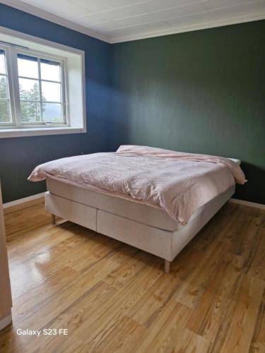 a bedroom with a bed and a wooden floor at Koselig hus i Valdres in Leira