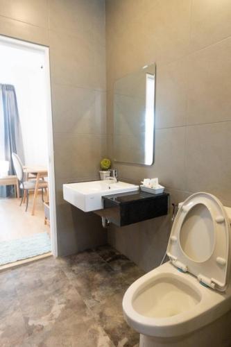 a bathroom with a toilet with a sink and a mirror at Pani House in Ban Nong Chaeng