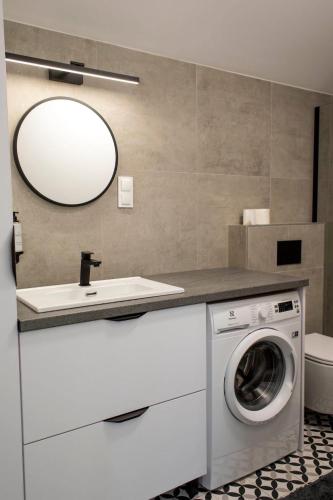 a bathroom with a washing machine and a mirror at Sosnowa Korona in Skorochow
