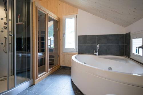 a large bathroom with a tub and a shower at Woody Park Feriendorf Murau in Murau