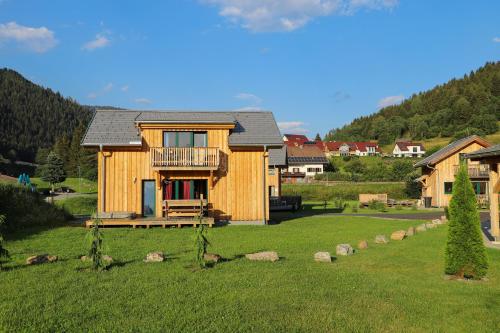 a wooden house in a field with a yard at Woody Park Feriendorf Murau in Murau