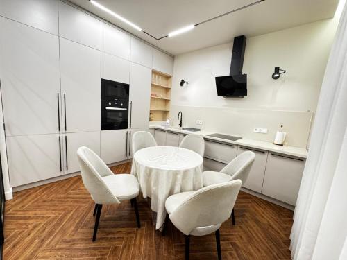 a white kitchen with a table and chairs at 4х комнатная Премиум класс возле Хан шатыра in Astana