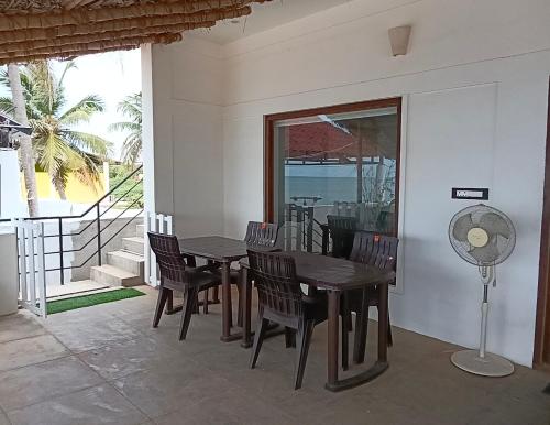 a dining room with a table and chairs and a fan at Villa Ande - Beach Homestay Pondicherry in Kālapettai