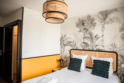 a bedroom with a bed with a tropical wallpaper at Domaine du Grand Caugy in Saint-Vigor-le-Grand