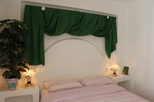 a bedroom with a bed with a green curtain at Aldea del Mar in Torrevieja