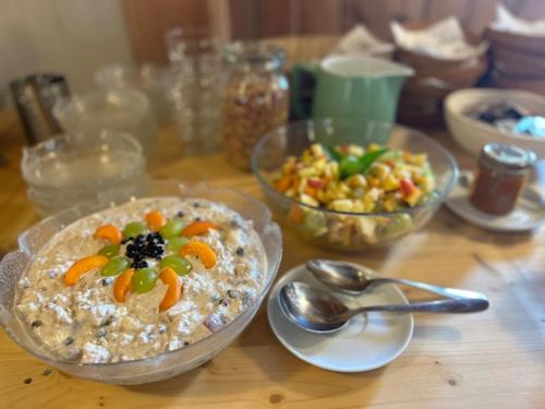 a wooden table topped with bowls of food and spoons at Tigia Val Surses 