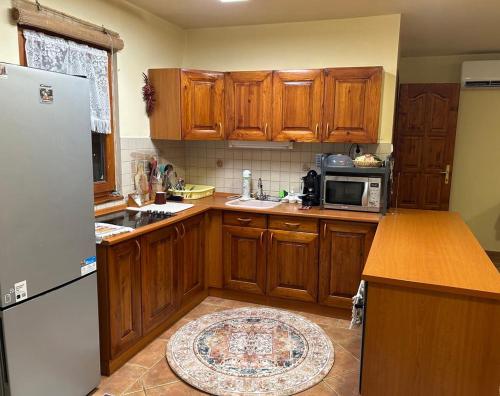 a kitchen with wooden cabinets and a refrigerator at Nyárfa Vendégház in Debrecen