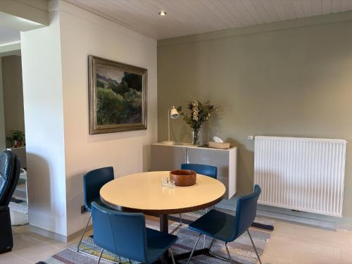 a dining room with a table and blue chairs at Bed en Natuur Puur in Herselt