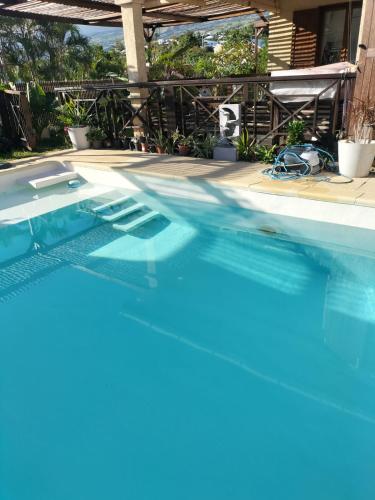 a swimming pool with blue water in a house at Ylang Ylang in Saint-Leu
