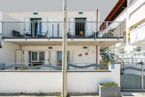 a white building with a balcony and a staircase at Affittacamere Marizzola in Cala Gonone