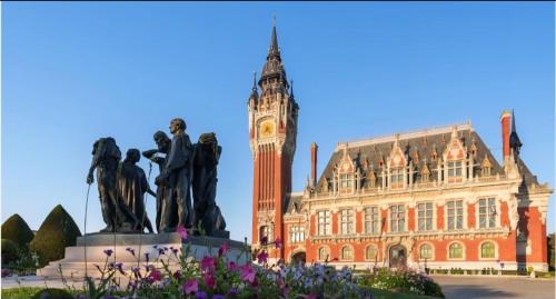 a statue in front of a building with a clock tower at La Marée in Calais