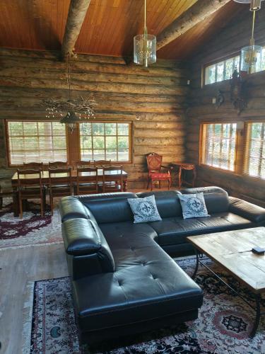 a living room with a leather couch and a table at Villa Lilja in Muurame