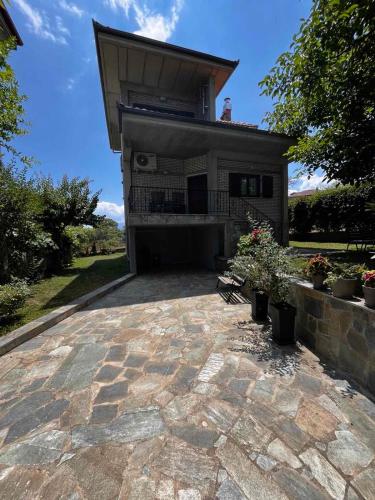 un patio de piedra frente a una casa en Ιξός Home, en (( Vría ))
