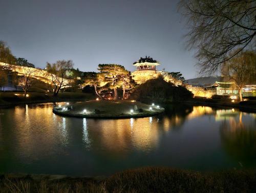 a view of a building with a pond at night at Haenggung-dong Stay in Suwon