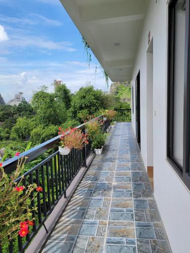 a balcony with potted plants on a railing at Tam Coc Gold Smile Homestay in Vũ Lâm