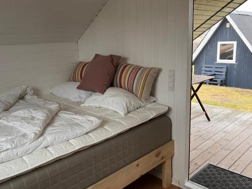 a couch with pillows sitting on top of a porch at Dancamps Nordsø Water Park in Hvide Sande