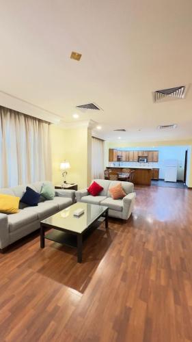 a living room with two couches and a table at القصر العالي للوحدات السكنية المفروشة in Al Khobar