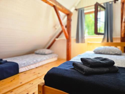 two beds in a room with towels on the bed at Martin's Family Cottage with Hot Tub & Views in Šmarje pri Jelšah