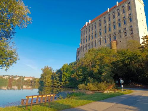 a large building next to a river with a building at Chalupa pod Zámkem in Plumlov