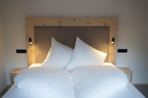 a large white bed with white pillows on it at LUSE Living in Maurach