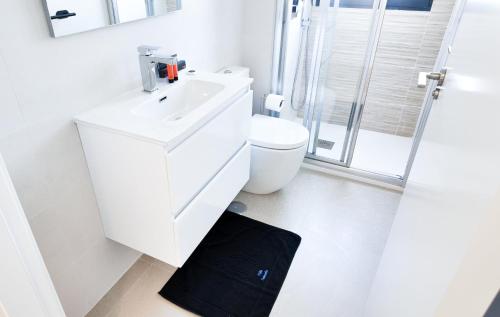 a white bathroom with a toilet and a sink at Villa Soleada in San Pedro del Pinatar