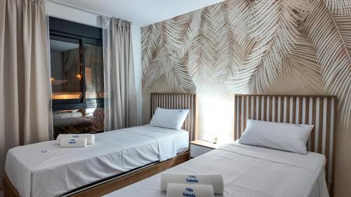 two beds in a hotel room with white sheets at Villa Soleada in San Pedro del Pinatar