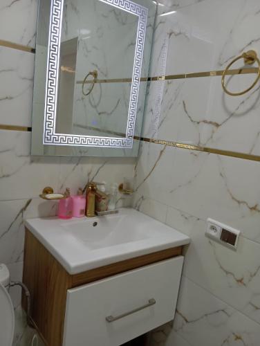 a bathroom with a sink and a mirror at Appartement a Oued laou complexe cité cinter in Oued Laou