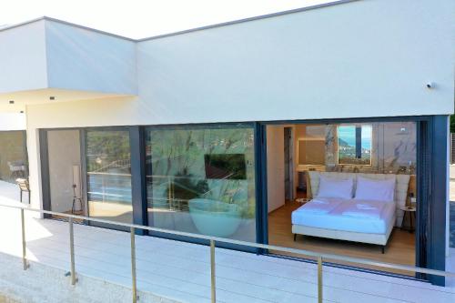 ein Zimmer mit einem Bett auf einem Balkon in der Unterkunft Villa Agapanthus in Veprinac