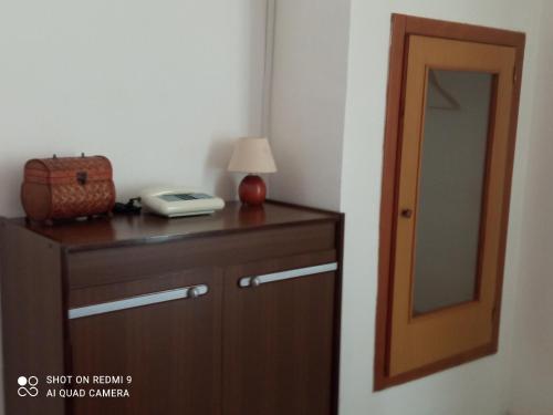 a room with a wooden dresser with a lamp and a mirror at Casa di Angela in Sannicola