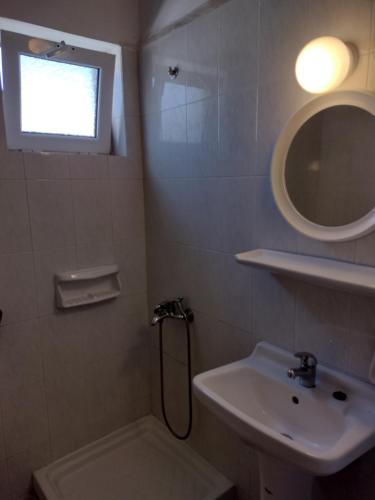 a bathroom with a sink and a shower and a mirror at Sunrise Studios Alykes in Alykes