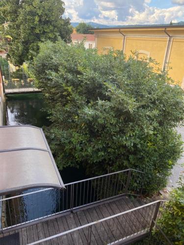 a walkway with bushes and a fence next to a river at La casa ai Laghetti in Montorio Veronese