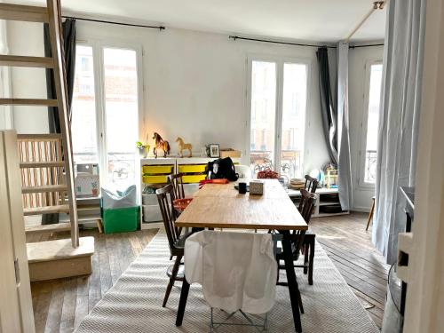 une salle à manger avec une table et des chaises en bois dans l'établissement Un appartement parisien atypique - An atypical Parisian appartment, à Paris