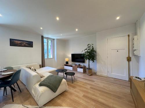 een woonkamer met een bank en een tafel bij Appartement entier Cosy in Grenoble
