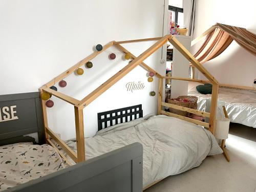 - une chambre pour enfants avec un lit doté d'un cadre en bois dans l'établissement Un appartement parisien atypique - An atypical Parisian appartment, à Paris