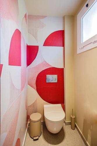 a bathroom with a toilet and a red and white wall at Rose Club Apartments in Laganas
