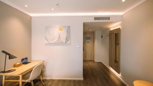 a room with a desk and a table and a hallway at Hanting Premium Beijing Wudaokou Tsinghua East Gate Hotel in Beijing