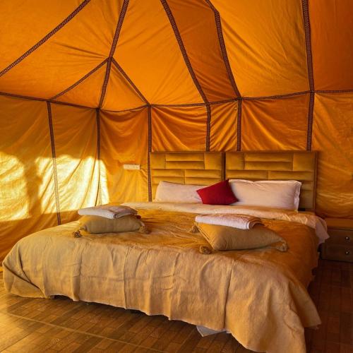 a bedroom with a bed in a large tent at Desert Nights Camp in Merzouga