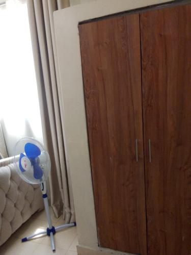 a room with a floor fan next to a cabinet at Stays with Fred in Ruiru