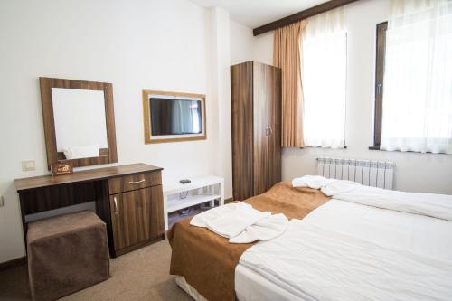 a bedroom with two beds and a vanity and a mirror at Borche Family Homes in Pamporovo